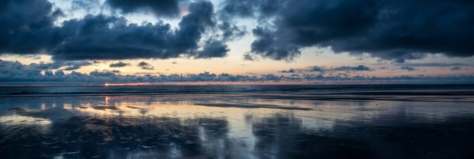 calm body of water under dark clouds